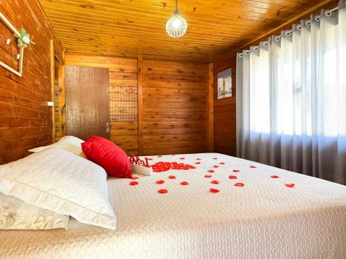 a bedroom with a bed with red roses on it at Sítio Raizes da Videira - SRR004 in Pinheiral