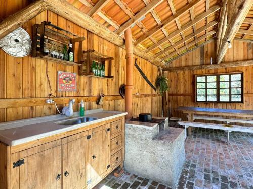 a kitchen with a sink in a wooden cabin at Sítio Raizes da Videira - SRR004 in Pinheiral