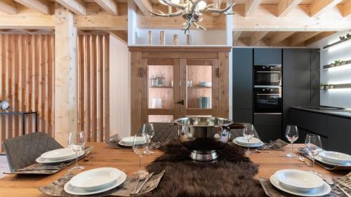 une salle à manger avec une table en bois et des verres à vin dans l'établissement Chalet De Tilia - CHALET PRESTIGE 8/10 PERS. PROCHE PISTES MAE-9931, à Vars