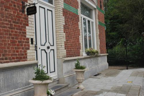 a front door of a house with two potted plants at B&B La Sucrerie in Amougies