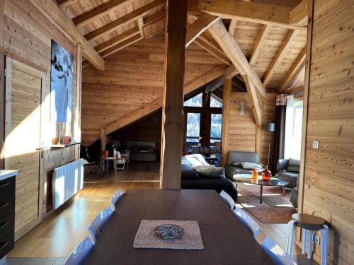 a living room with a table in a wooden house at Chalet Mountainside - CHALET MOUNTAIN SIDE Tout inclus Classé 4 MAE-9971 in Vars
