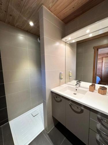 une salle de bain avec un lavabo et un miroir dans l'établissement Chalet Mountainside - CHALET MOUNTAIN SIDE Tout inclus Classé 4 MAE-9971, à Vars