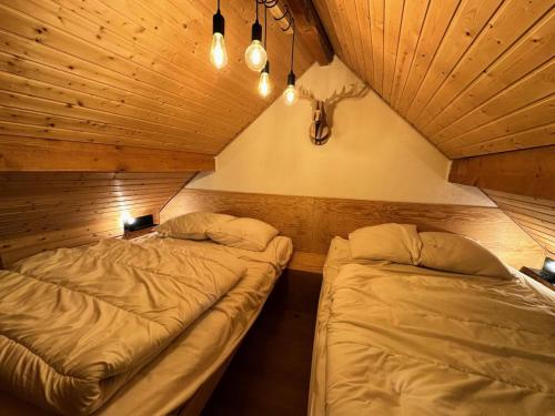 deux lits dans une chambre avec plafonds en bois dans l'établissement Résidence L'hostellerie - APPARTEMENT SAINTE MARIE MAE-0041, à Vars