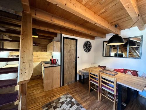 une cuisine et une salle à manger avec une table et des chaises en bois dans l'établissement Résidence L'hostellerie - APPARTEMENT SAINTE MARIE MAE-0041, à Vars