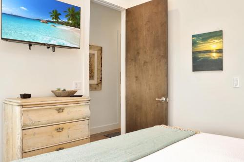 a bedroom with a bed and a tv on the wall at Rejuvenation by Pristine Properties Vacation Rentals in Saint Joe Beach