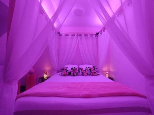 - une chambre rose avec des ours en peluche sur un lit dans l'établissement Le Royaume des Sens, à Sainte-Opportune-du-Bosc