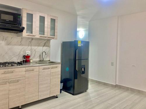 a kitchen with a stainless steel refrigerator in a room at Apartahotel Poblado-Aguacatala in Envigado