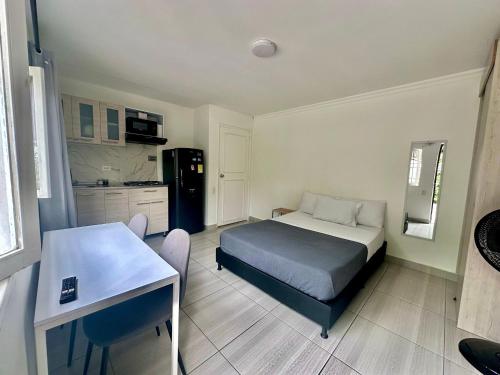 a small bedroom with a bed and a kitchen at Apartahotel Poblado-Aguacatala in Envigado