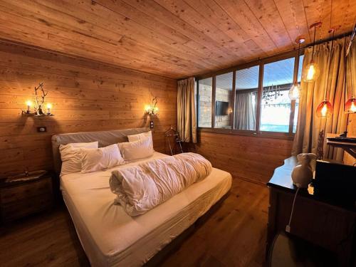 ein Schlafzimmer mit einem Bett in einem Holzzimmer in der Unterkunft Résidence Les Ecrins 1 - RESIDENCE LES ECRINS 1 MAE-0421 in Vars