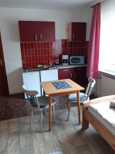 a small kitchen with a wooden table and chairs at Appartement Pension Feist in Dagebüll