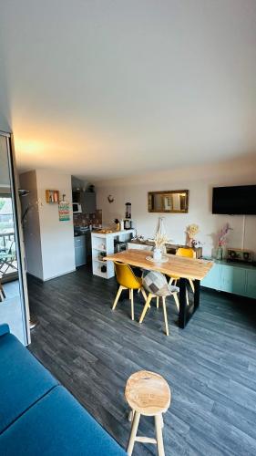 un salon avec une table et une cuisine dans l'établissement Joli Appartement à 100m de la plage, à Carnac