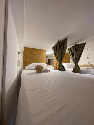 a bedroom with a large white bed with curtains at Mahalo Hostel in Salento