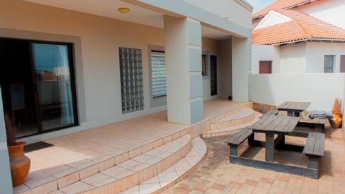 a patio with two benches on a house at Coastal Beach Bliss in Langstrand