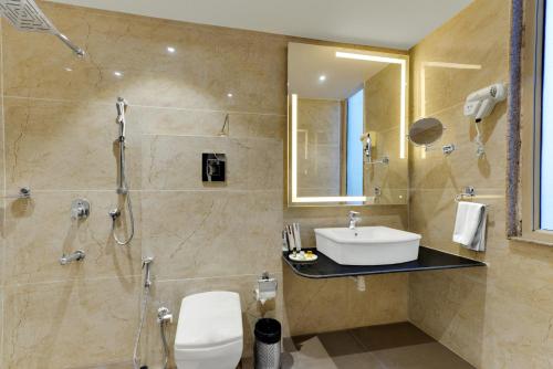 a bathroom with a sink and a shower and a toilet at The Royal Melange Beacon in Ajmer