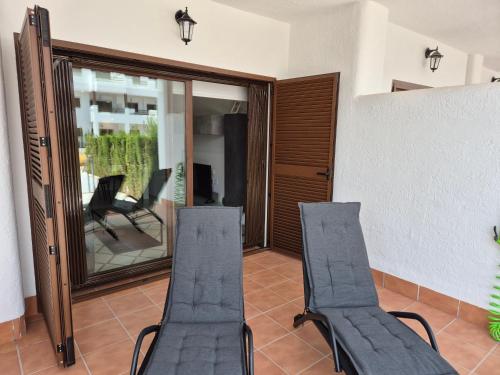 two chairs in a living room with a mirror at Casa Ariella in San Juan de los Terreros