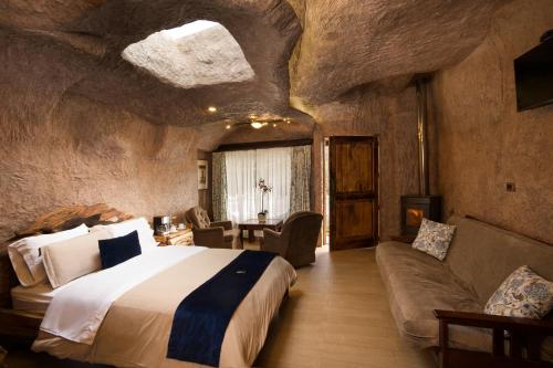 a bedroom with a large bed and a couch in a cave at Estancia San Juan in Cuenca