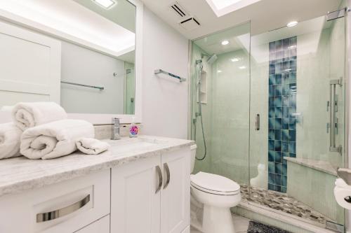 een badkamer met toilet en glazen douche bij 2 BR Condo by the Beach - Splendid Ocean View in Marco Island