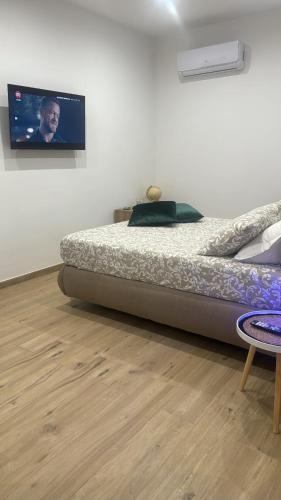 a bedroom with a bed and a tv on the wall at RG MAISON - Suite 29 in Morino