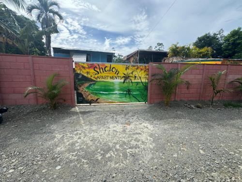 a fence with a mural on the side of it at Shalon Apartments 5 personas in Cahuita