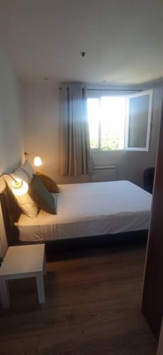 une chambre avec un grand lit avec une fenêtre dans l'établissement Appartement 2 pièces à 150 m de la plage, à Marseille