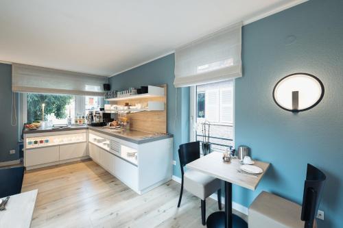 a kitchen with blue walls and a table and a dining room at Hotel Busche am Dom in Münster