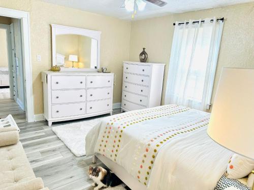 a bedroom with a bed and a dresser and a cat sitting on the floor at Nest of beauty in Niagara Falls in Niagara Falls