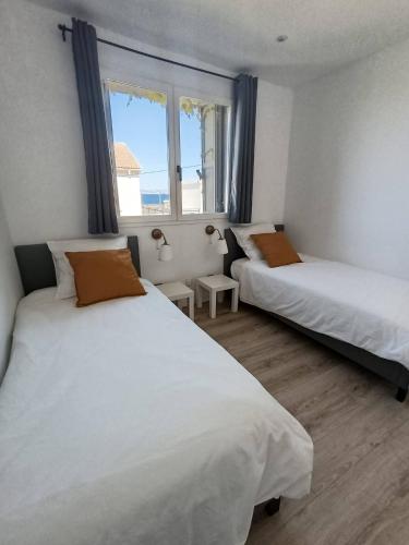 une chambre avec deux lits et une fenêtre dans l'établissement Appartement 3 chambres avec terrasse vue mer à 150 m de la plage, à Marseille