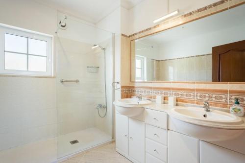 a bathroom with two sinks and a shower at Villa Nascente Balaia in Branqueira