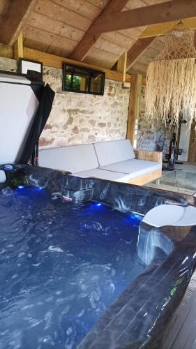- une piscine d'eau avec un lit dans une chambre dans l'établissement Gîte Les Pampas Les Jardins de Kerellec 20min de la mer 2 à 4 personnes jacuzzi et terrasse, à Plouvorn