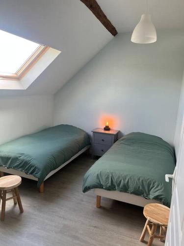 une chambre avec deux lits et une table et une fenêtre dans l'établissement Maison au calme, à Baccon