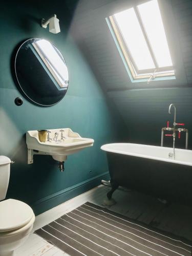 une salle de bain avec une baignoire, un lavabo et un miroir dans l'établissement Maison de charme proche mer, à Blainville-sur-Mer