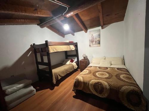 a bedroom with a bed and a bunk bed at Cabaña en Tapalpa Morada de Cervantes Don Quijote in Tapalpa