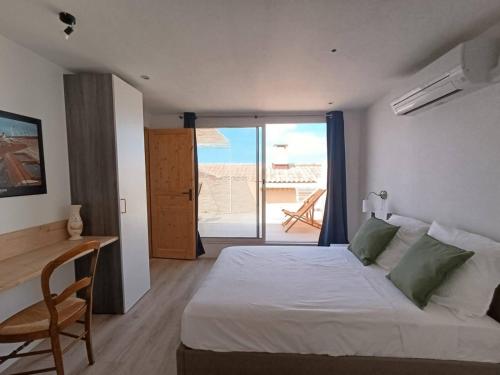 une chambre avec un lit et un bureau et un balcon dans l'établissement Penthouse 2 pièces avec terrasse vue mer à 150 m de la plage, à Marseille