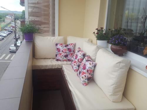 a white couch sitting on a balcony with pillows at Apartament in Lugoj Gabriela in Lugoj