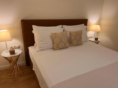 a bed with white sheets and pillows in a bedroom at Top View Residence in Hvar