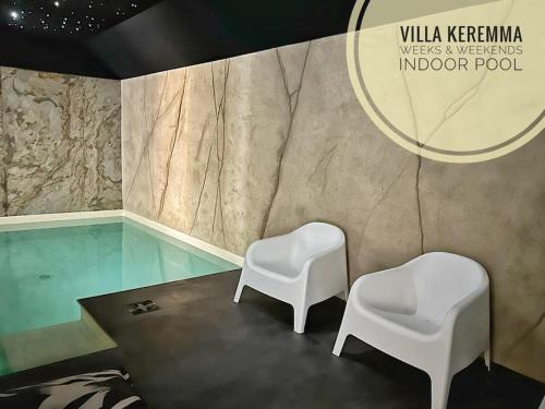 - deux chaises blanches dans une chambre avec piscine dans l'établissement La Villa Keremma - Luxe - Piscine et plage, à Plounéour-Trez