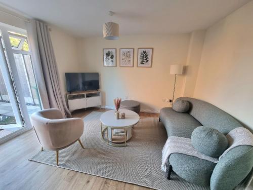 a living room with a couch and chairs and a tv at Stylish Spacious 4 Bed Townhouse near station with Parking & High Speed WiFi in Rugby