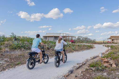 two people riding bikes down a dirt road at Viatura Hacienda Xtojil, Yucatan, Merida, with Optional All Inclusive in Sotuta de Peón