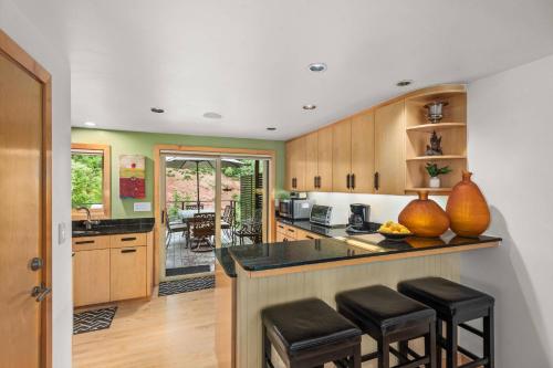 a kitchen with wooden cabinets and black counter stools at Le Chamonix #11 Aspen Highlands in Aspen