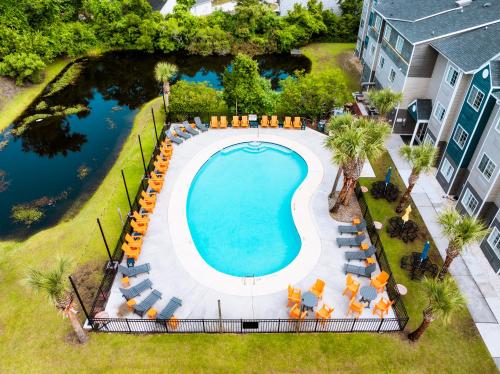 an overhead view of a swimming pool with chairs and trees at The Windstar Hotel - Carolina Beach in Carolina Beach