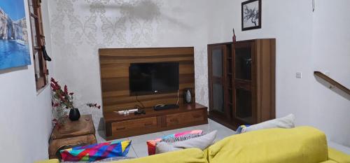 a living room with a yellow couch and a television at 3 Floors Villa on Promenade 4 bedrooms 3 bathrooms V1 in Sliema