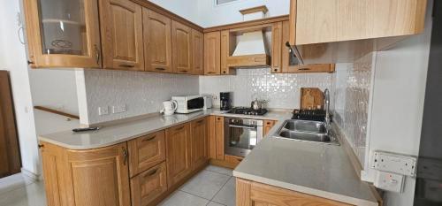 a small kitchen with wooden cabinets and a sink at 3 Floors Villa on Promenade 4 bedrooms 3 bathrooms V1 in Sliema