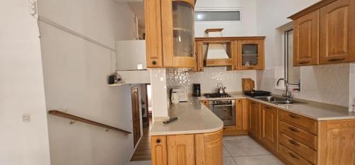 a kitchen with wooden cabinets and stainless steel appliances at 3 Floors Villa on Promenade 4 bedrooms 3 bathrooms V1 in Sliema