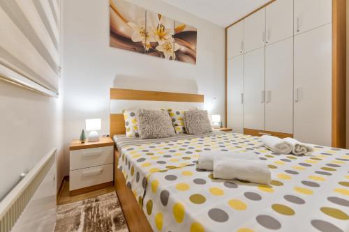 a bedroom with a large bed with yellow and white sheets at Harmonija NM in Zlatibor