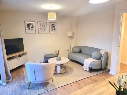 a living room with a couch and a tv at Stylish Spacious 4 Bed Townhouse near station with Parking & High Speed WiFi in Rugby
