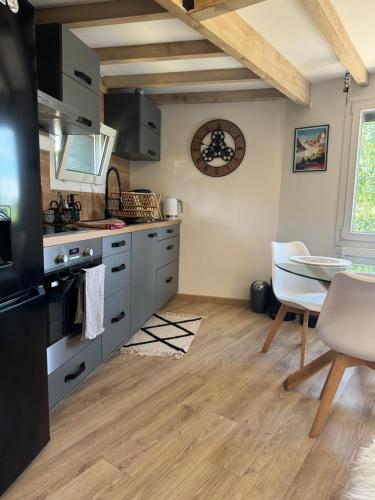 une cuisine avec des appareils en acier inoxydable et une table dans l'établissement Chalet Pagotin - Le Renversant, à Métabief