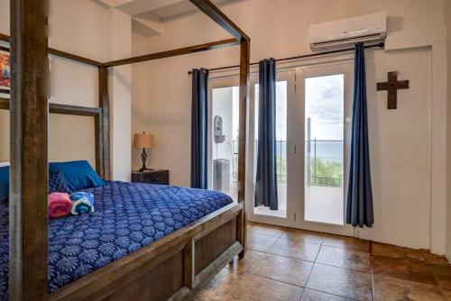 a bedroom with a bed and a cross on the wall at Villa del Enseuno- Pristine View and Infinity Pool in Luquillo