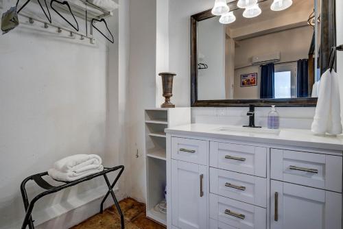 a bathroom with a sink and a mirror and a chair at Villa del Enseuno- Pristine View and Infinity Pool in Luquillo