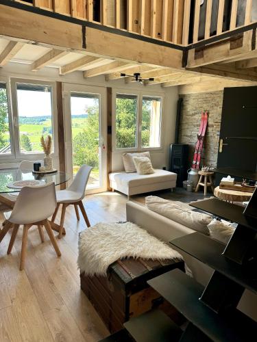un salon avec un canapé et une table dans l'établissement Chalet Pagotin - Le Renversant, à Métabief