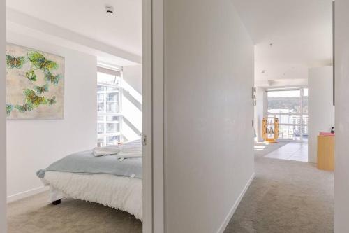a bedroom with a bed in a white room at Harbor View Two Bedroom Apartment At Pinnacle in Wellington